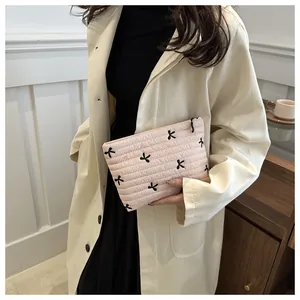 Detailansicht der rosa gesteppten Kosmetiktasche mit schwarzen Schleifen-Stickereien