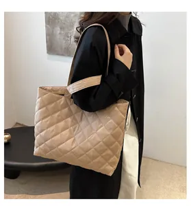 Gros plan sur le sac cabas matelassé beige avec large bandoulière et texture détaillée