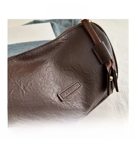 Detail view of brown lychee grain PU leather bag with Fashion logo and gold hardware