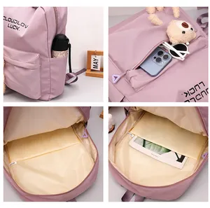 Détail du sac à dos violet montrant les compartiments organisés et le charm d'ours