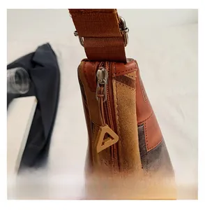 Dettaglio ravvicinato della cerniera e delle texture della grande borsa marrone