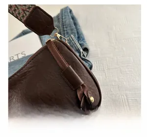 Detail of dark brown leather pillow bag featuring rivet decor and woven geometric strap