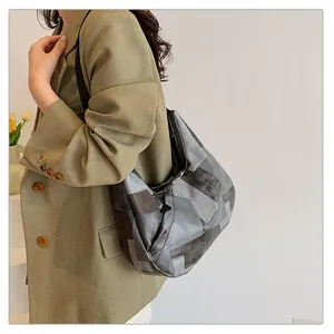 Dettaglio della borsa tote grigia a pieghe patchwork indossata da una modella