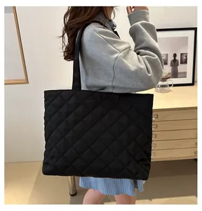 Détail du sac cabas matelassé noir avec motif en losange et bandoulière confortable