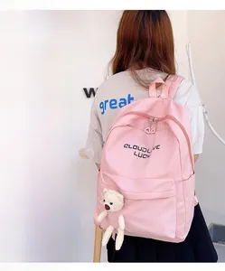 Sac à dos rose minimaliste avec logo lucky et un petit porte-clés ours en peluche blanc