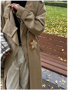 Sac bandoulière chic en forme d'étoile dorée avec strass, porté par un mannequin en plein air