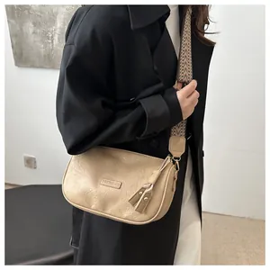 Detail of beige wrinkled texture bag with fashion logo and jacquard wide strap