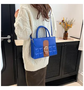 Detail view of Klein blue quilted crossbody bag with stylish gold-tone hardware and handle