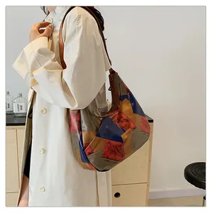 Modella che indossa una grande borsa tote in pelle patchwork con pannelli multicolore