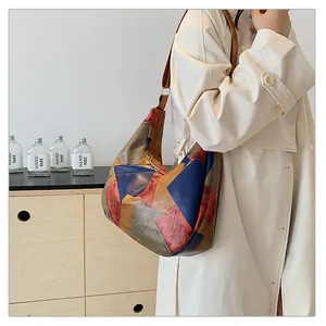 Vista dettagliata della grande borsa tote in pelle color-block su trench beige
