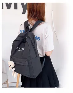 Détail d'un sac à dos noir en nylon avec pendentif ours en peluche et logo CLOUDLOV