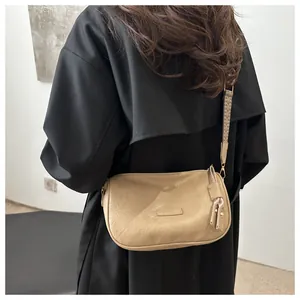 Detail of khaki crossbody pillow bag featuring a wide jacquard patterned shoulder strap