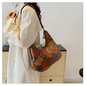 Dettaglio della borsa hobo vintage in pelle patchwork con toni della terra e zip