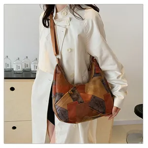 Dettaglio della borsa tote patchwork vintage con tracolla regolabile su un modello in trench