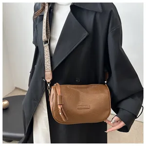 Brown pleated pillow bag with FASHION label and wide woven pattern crossbody strap