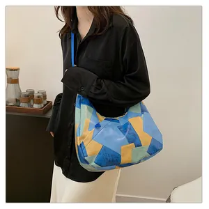 Modella che indossa una grande borsa tote in pelle patchwork multicolore estiva
