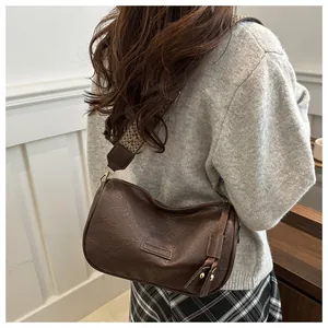 Macro detail of brown retro faux leather pillow bag with colorful woven shoulder strap