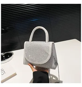 Close-up of sparkling silver rhinestone handbag with metallic chain and handle