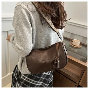 Detail of dark brown PU leather crossbody bag with ethnic style woven shoulder strap