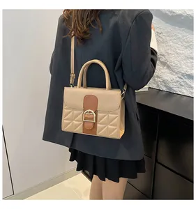 Detail of retro color-block handbag with textured diamond pattern and golden metal buckle
