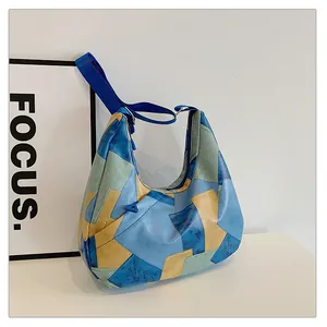 Dettaglio della borsa hobo con pannelli geometrici in ecopelle e tracolla in nylon blu