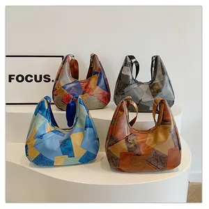 Quattro varianti di borse hobo patchwork retrò esposte su piedistalli bianchi eleganti