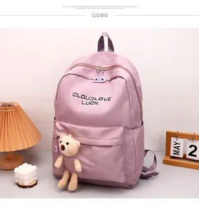 Détail du sac à dos en nylon lilas avec pendentif ours en peluche et logo imprimé