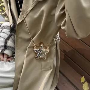 Sac bandoulière doré en forme d'étoile avec strass étincelants et chaîne en métal fin