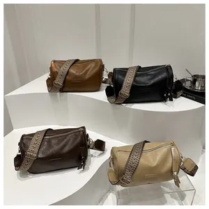 Detail of multi-color cylinder crossbody bags with wide patterned jacquard straps