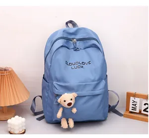Détail du sac à dos bleu pour étudiant avec texte CLOUDLOVE LUCK et pendentif ours