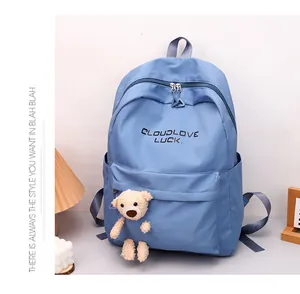 Vue détaillée du sac à dos bleu ciel avec imprimé Cloudlove et breloque ourson