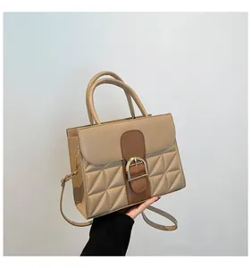 Detail of khaki leather handbag with contrast brown trim and golden horseshoe buckle