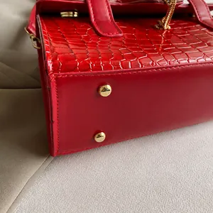 Detailansicht der roten Krokodil-Lederhandtasche mit goldenen Bodennägeln