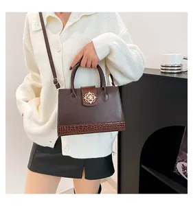 Detail of vintage coffee brown crossbody bag with gold flower buckle and croc pattern