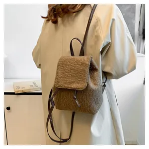 Detail shot of brown fuzzy faux shearling backpack with dark brown leather straps