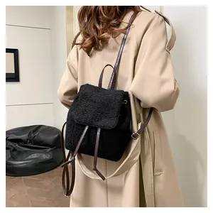 Detail of black faux shearling mini backpack with brown leather straps and drawstring