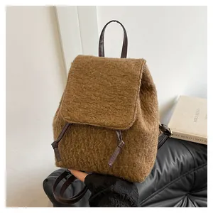 Detail of brown plush faux fur backpack with leather straps and drawstring closure
