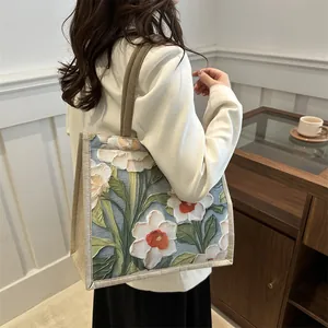 Minimalist canvas tote bag with 3D floral embroidery and brown shoulder straps