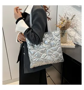 Chic silver quilted tote bag shown on a model's shoulder for a modern fashion look