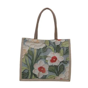 Minimalist tote bag featuring elegant floral pattern on woven jute canvas texture