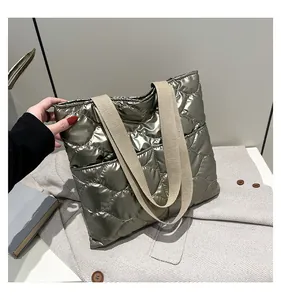 Macro detail of quilted silver-green tote bag with metallic texture and woven strap