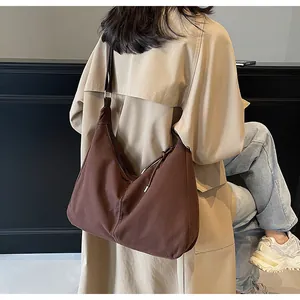 Retro brown canvas hobo bag worn by model, showing its large capacity and drape