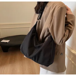 Detail of black canvas Hobo bag with white contrast stitching and slim shoulder strap