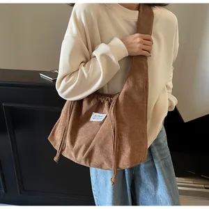 Détail d'un sac cabas en velours côtelé marron avec texture et fermeture à cordon