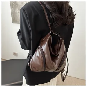 Vue arrière d'un mannequin portant un sac hobo rétro marron foncé avec détails zippés