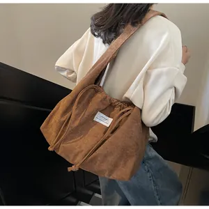 Gros plan détaillé du sac cabas en velours côtelé marron avec cordon de serrage