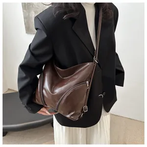 Détail d'un sac bandoulière marron en cuir PU avec fermeture éclair sur un mannequin