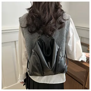 Détails du sac à dos triangulaire en cuir noir avec fermetures éclair métalliques argentées