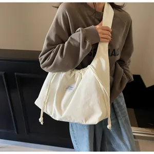 Détail du sac fourre-tout en velours côtelé blanc cassé avec cordon de serrage et étiquette