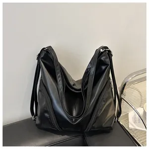 Détail d'un sac à dos noir en PU brillant avec fermetures éclair et sangles fonctionnelles